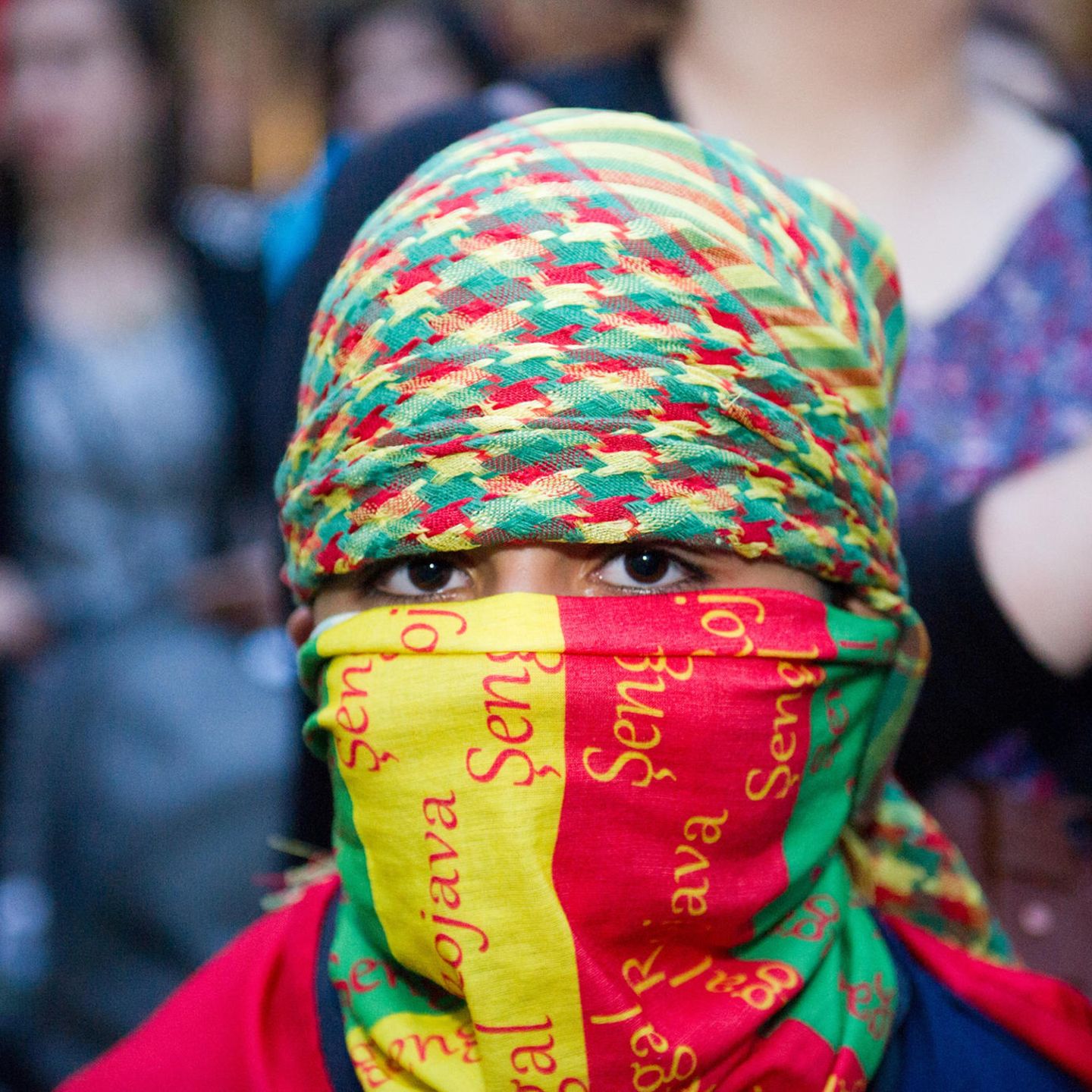 Ein kleiner Junge in den kurdischen Nationalfarben vermummt