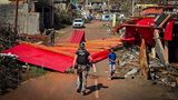 Ein französischer Gendarme, der am 15. Dezember in Mayotte zwischen Trümmern geht