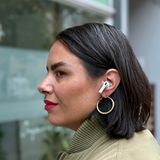 Die Airpods 4 von Apple blockieren für eine junge Frau Straßenlärm