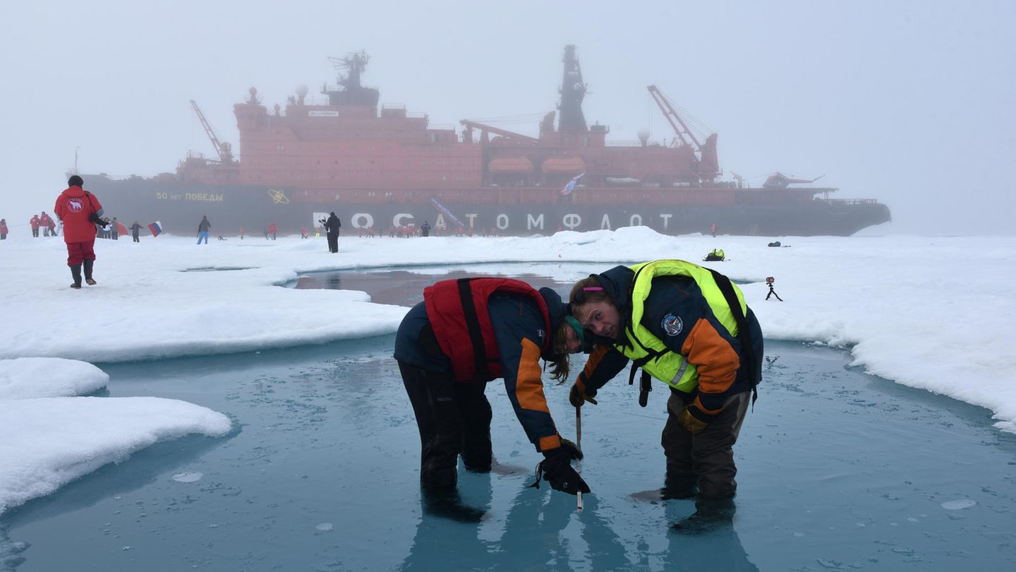 Wissenschaftler messen einen Schmelztümpel auf der Meereseisdecke am Nordpol aus