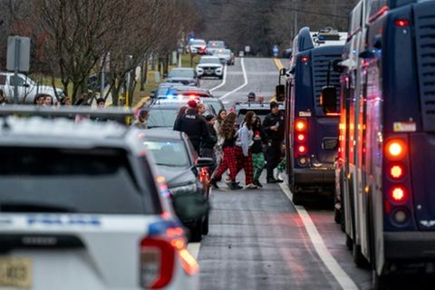 Schüler werden zur Abholung zu einem Bus eskortiert
