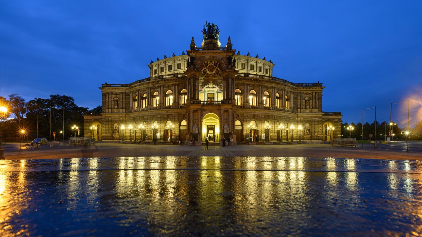 Blick am Abend auf die beleuchtete Semperoper auf dem Theaterplatz in Dresden