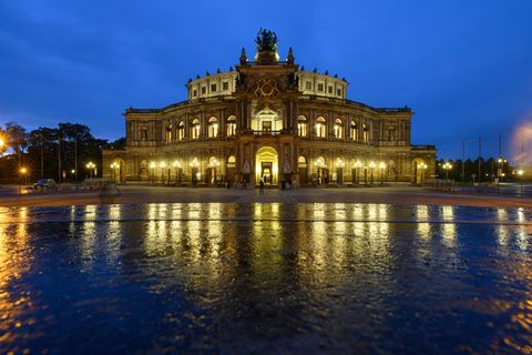 Blick am Abend auf die beleuchtete Semperoper auf dem Theaterplatz in Dresden