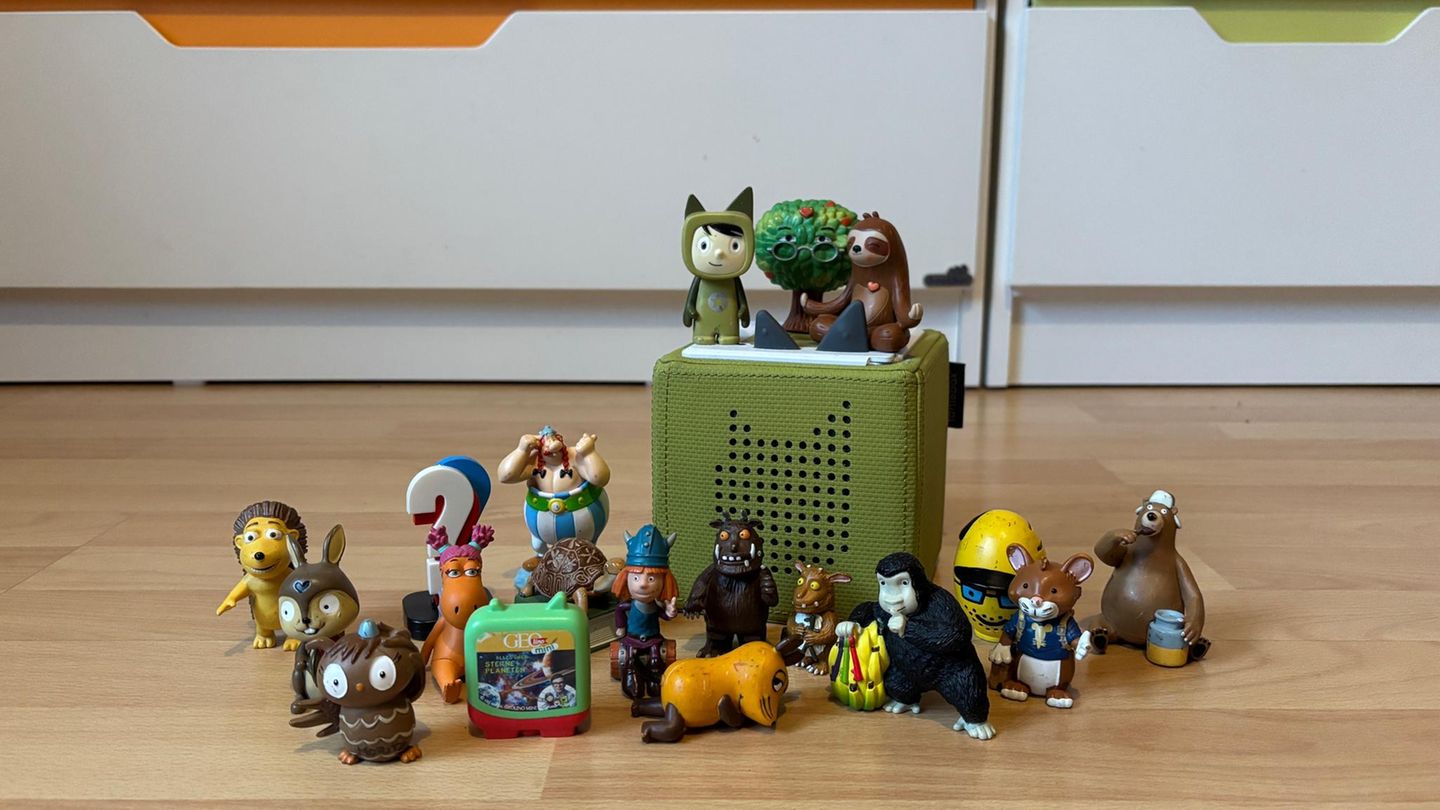 Tonie Hörfiguren: Etwa 20 Tonies stehen neben einer grünen Toniebox