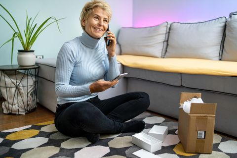 Frau packt das neue Samsung Galaxy S24 aus und verschickt ihr Altgerät.