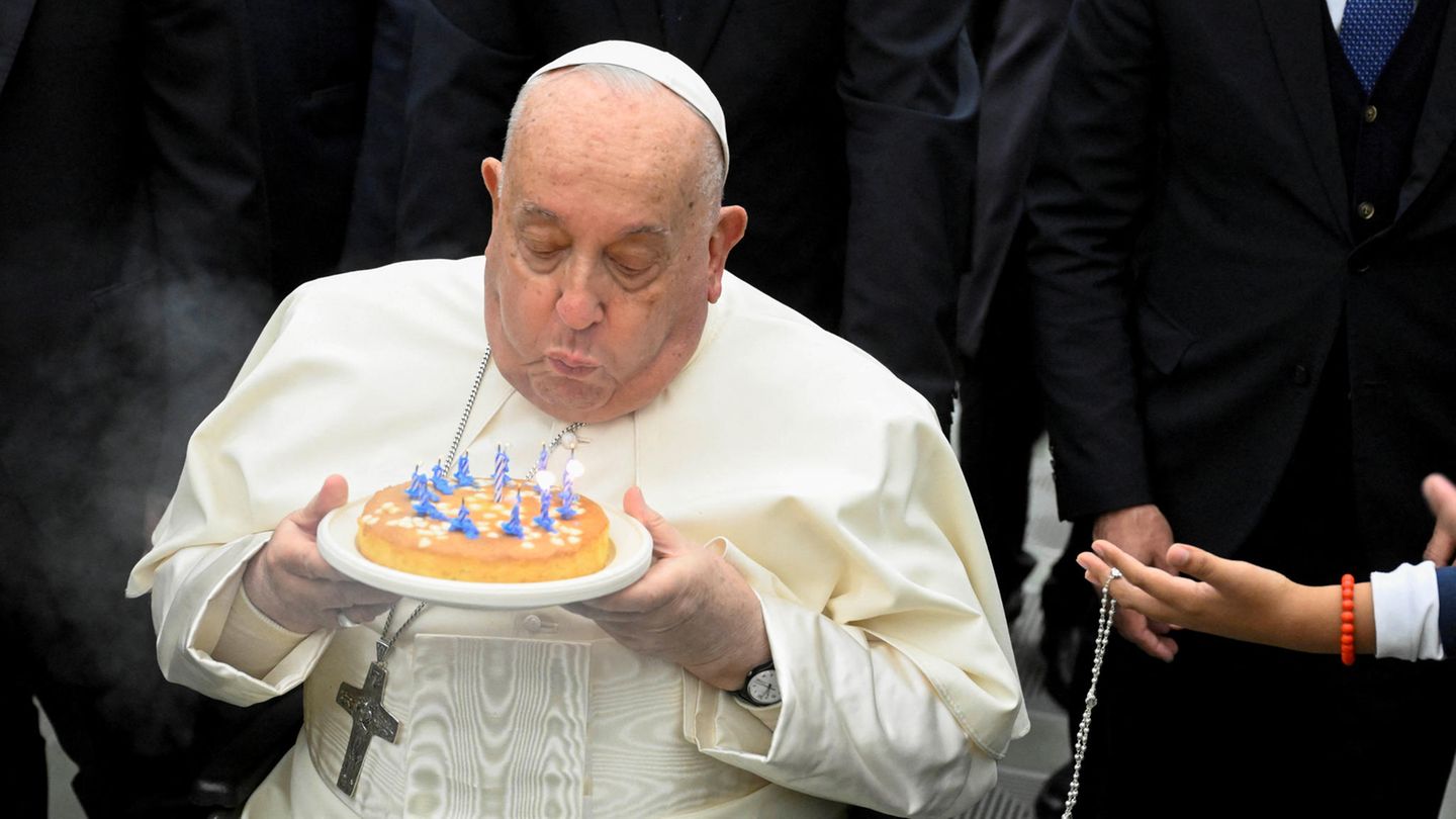 Papst Franziskus bläst Kerzen auf einem Kuchen aus