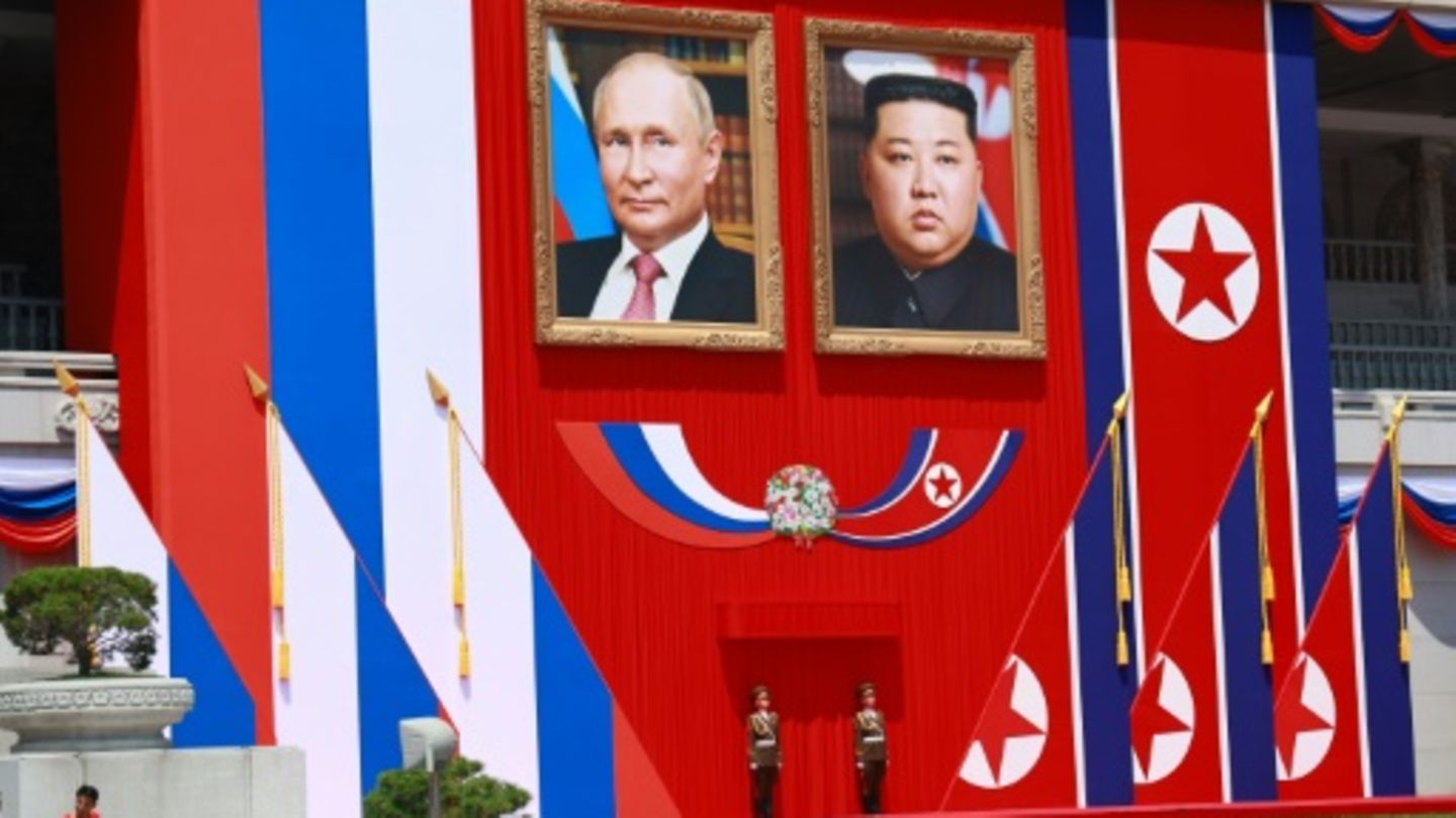 Porträts von Präsident Putin und Machthaber Kim