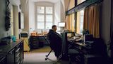 Pater Godehard sitzt im inneren der Pforte im Büro