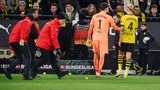 Ordner entfernen bei einem Dortmund-Spiel Tennisbälle vom Spielfeld