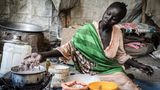Nyikueth Chuol Yoah, 20, kocht mit den Nahrungsmitteln der Caritas