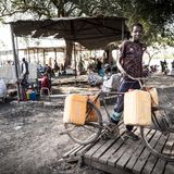 Yai Ngor, 12, transportiert Wasser aus dem Nil. Er ist kein Rückkehrer, er verkauft Wasser, um seine alleinerziehende Mutter zu unterstützen