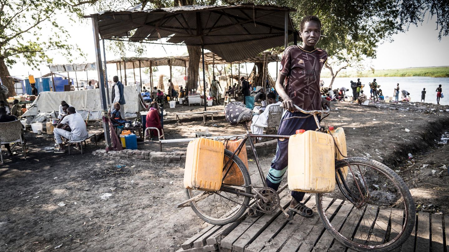 Yai Ngor, 12, transportiert Wasser aus dem Nil. Er ist kein Rückkehrer, er verkauft Wasser, um seine alleinerziehende Mutter zu unterstützen