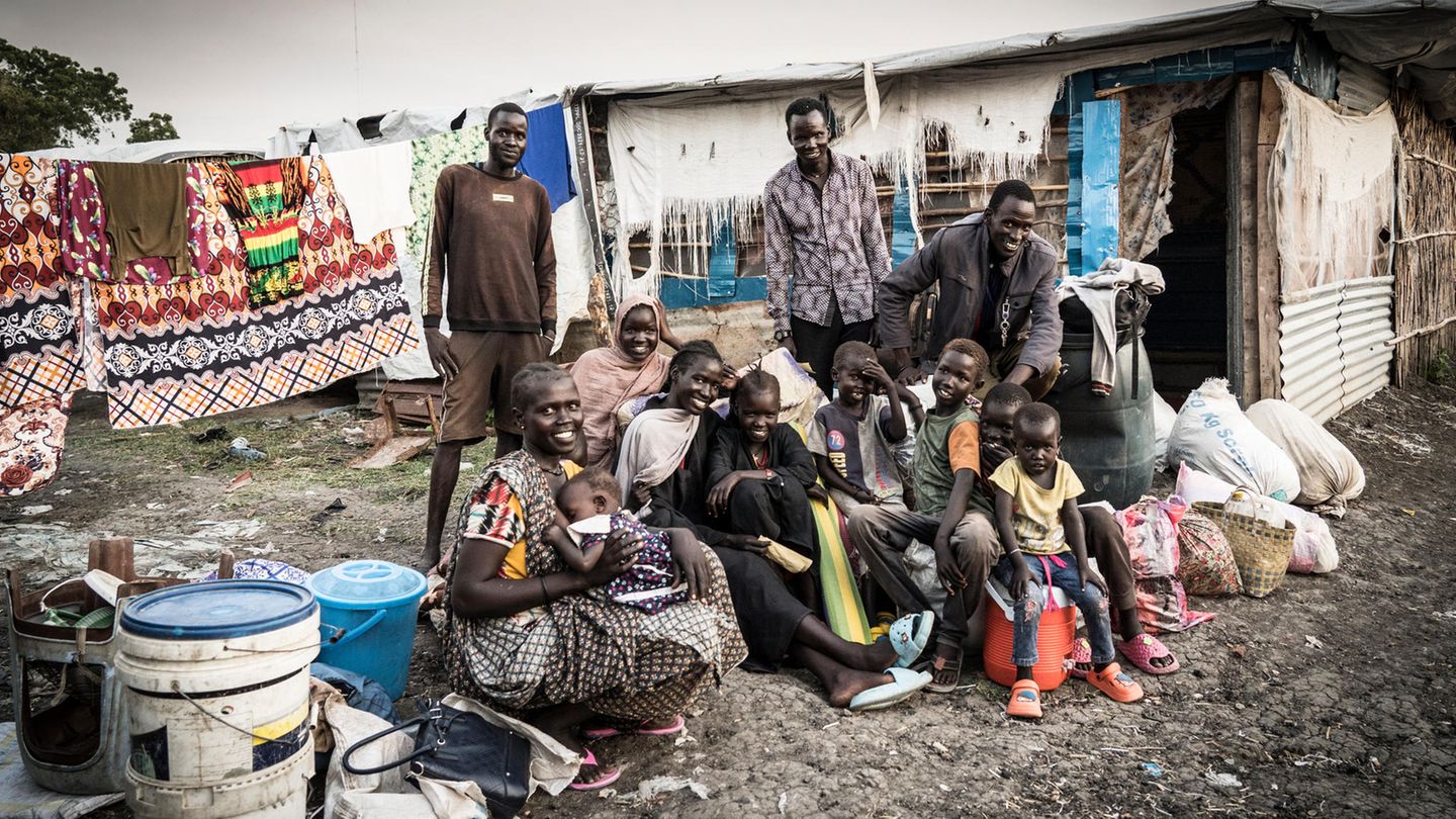 Auch diese Familie ist gerade mit dem Schiff aus Renk angekommen ist. Sie musste sich selbst irgendwie eine Unterkunft im Camp suchen. Die Baracke im Hintergrund ist schon besetzt. Nur ein Teil der Familie kann dort für eine Nacht unterkommen, der Rest muss unter freiem Himmel schlafen