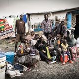 Auch diese Familie ist gerade mit dem Schiff aus Renk angekommen ist. Sie musste sich selbst irgendwie eine Unterkunft im Camp suchen. Die Baracke im Hintergrund ist schon besetzt. Nur ein Teil der Familie kann dort für eine Nacht unterkommen, der Rest muss unter freiem Himmel schlafen