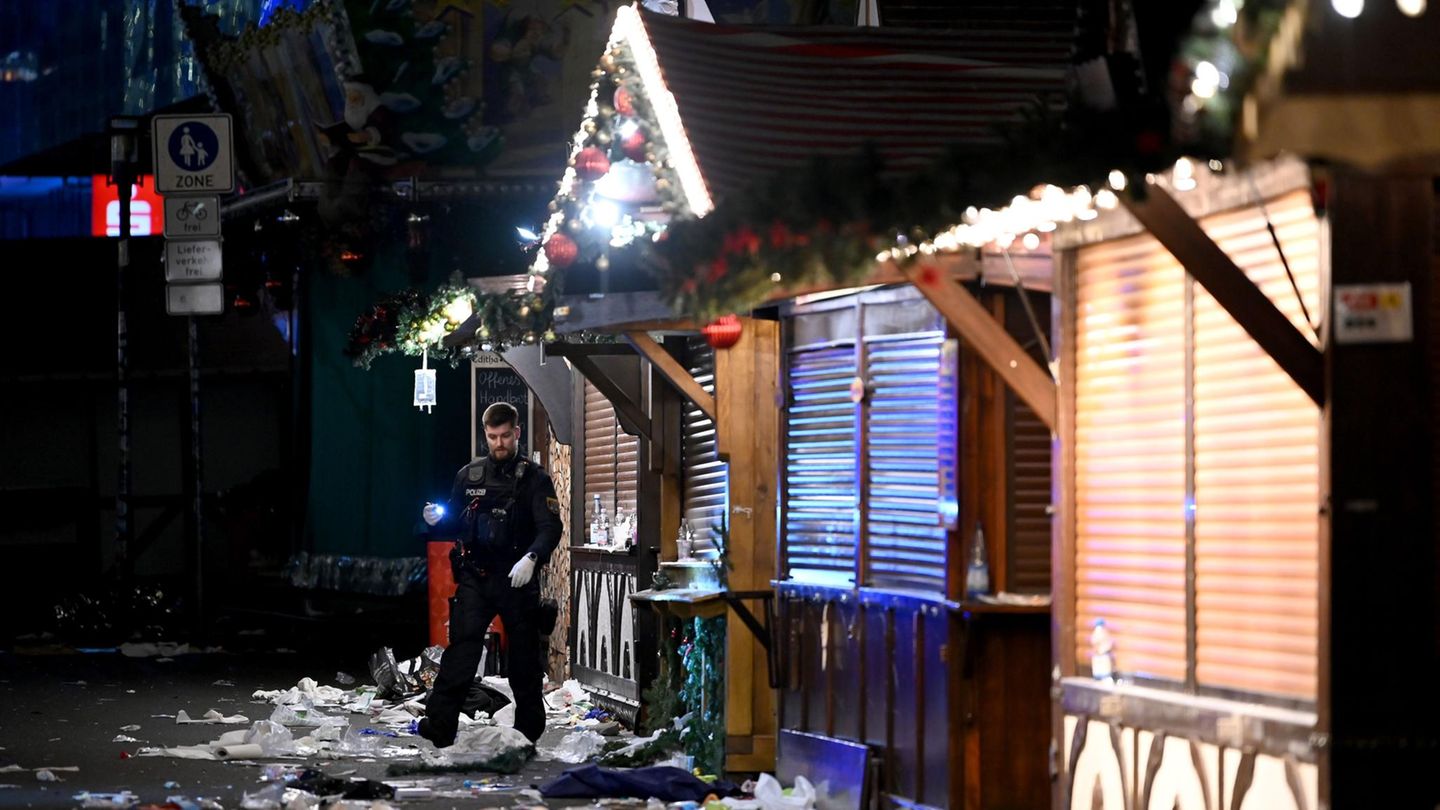 Ein Polizist untersucht den Tatort auf dem Weihnachtsmarkt in Magdeburg