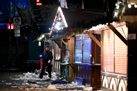 Ein Polizist untersucht den Tatort auf dem Weihnachtsmarkt in Magdeburg