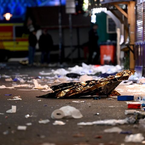 Im Nachhinein: Verwüstung und ein leerer Weihnachtsmarkt in Magdeburg. Im Hintergrund ein Krankenwagen