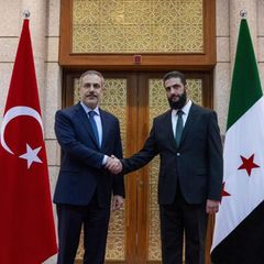 Handschlag zwischen dem türkischen Außenminister Hakan Fidan (l.) und Ahmed al-Sharaa, früher bekannt als Abu Mohammed al-Dschulani, dem Anführer der Milizen in Syrien
