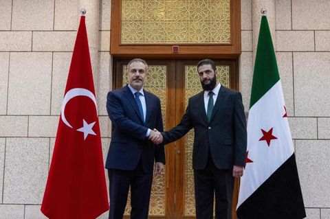Handschlag zwischen dem türkischen Außenminister Hakan Fidan (l.) und Ahmed al-Sharaa, früher bekannt als Abu Mohammed al-Dschulani, dem Anführer der Milizen in Syrien