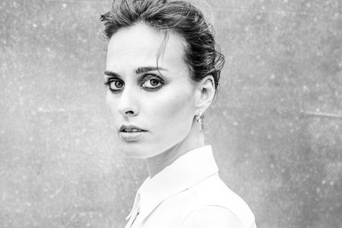 Sophie Auster, eine Frau in Bluse, mit hochgesteckten Haaren und großen Augen, schaut in die Kamera