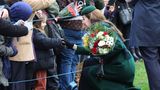 Prinzessin Kate kniet und hält einen Blumenstrauß