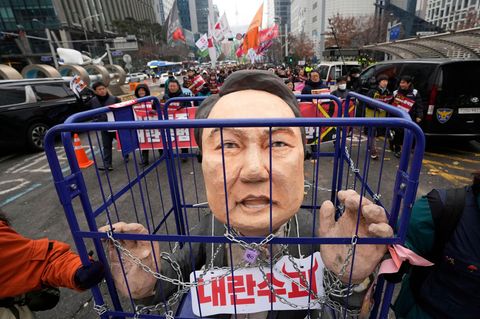 Demonstranten tragen eine Karikatur des abgesetzten südkoreanischen Präsidenten während einer Kundgebung, die seine Verhaftung fordert