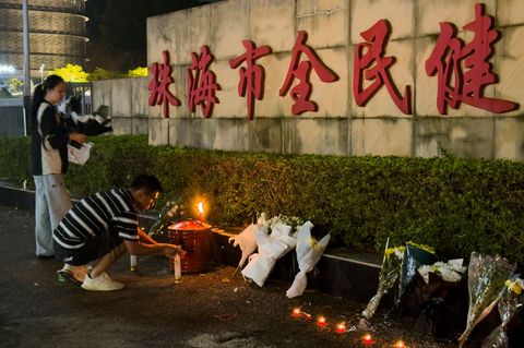Ein Mann zündet eine Kerze vor dem "Zhuhai People's Fitness Plaza" in China an. Hier war der Mann mit seinem Auto absichtlich in eine Menschenmenge gerast. (Archivbild)