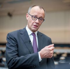 Friedrich Merz trägt Anzug und Krawatte und gestikuliert