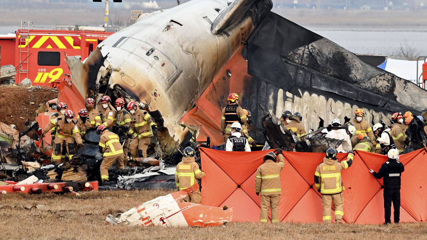 In Südkorea arbeiten Rettungsmannschaften nach einem Flugzeugunglück am Wrack der Maschine