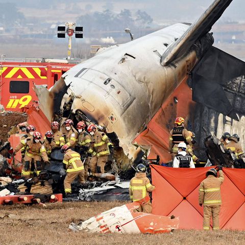 In Südkorea arbeiten Rettungsmannschaften nach einem Flugzeugunglück am Wrack der Maschine