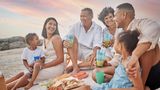 In Südafrika sitzen Erwachsene und Kinder bei einem Silvester-Picknick am Strand