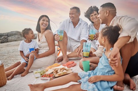 In Südafrika sitzen Erwachsene und Kinder bei einem Silvester-Picknick am Strand