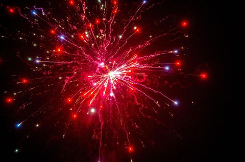 Eine Silvester-Rakete explodiert rot im Nachthimmel über Deutschland: Wetter