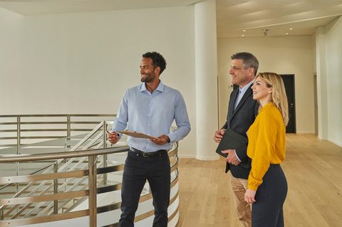 Ein Immobilien-Makler zeigt einem Paar eine luxuriöse Wohnung