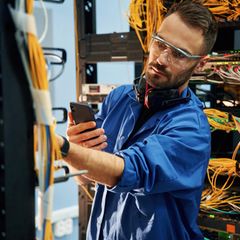 Ein IT-Mitarbeiter im Serverraum einer Firma