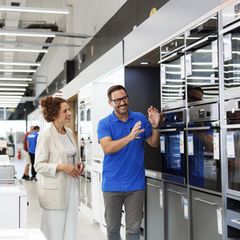 Ein Experte für Küchengeräte mit einer Kundin