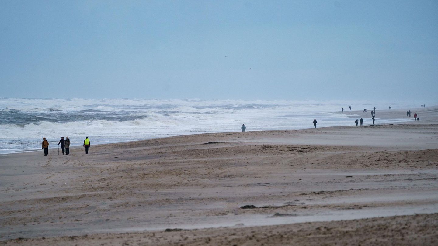 Spaziergänger gehen am Strand von Westerland auf der Nordseeinsel Sylt entlang
