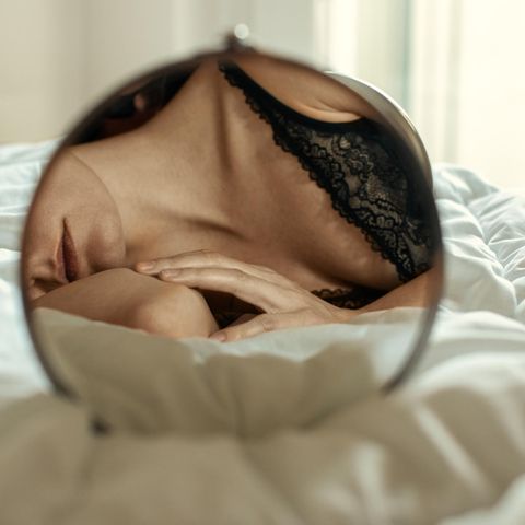 Spiegelbild einer Frau auf dem Bett liegend