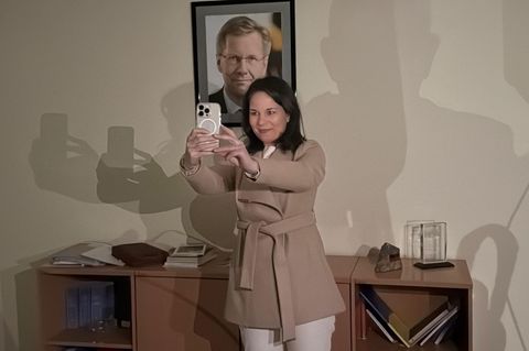 Außenministerin Annalena Baerbock macht ein Selfie vor dem Porträt des ehemaligen Bundespräsidenten Christian Wulff