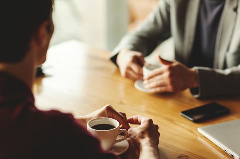 Zwei Personen sitzen am Tisch und unterhalten sich