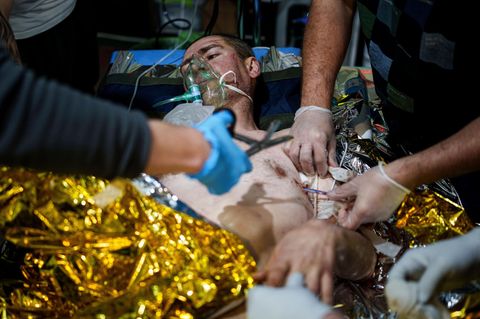 Sanitäter im Kriegseinsatz in der Ukraine behandeln einen Patienten