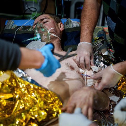 Sanitäter im Kriegseinsatz in der Ukraine behandeln einen Patienten