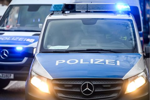 Polizeiautos mit eingeschalteten Scheinwerfern und Blaulicht in Berlin