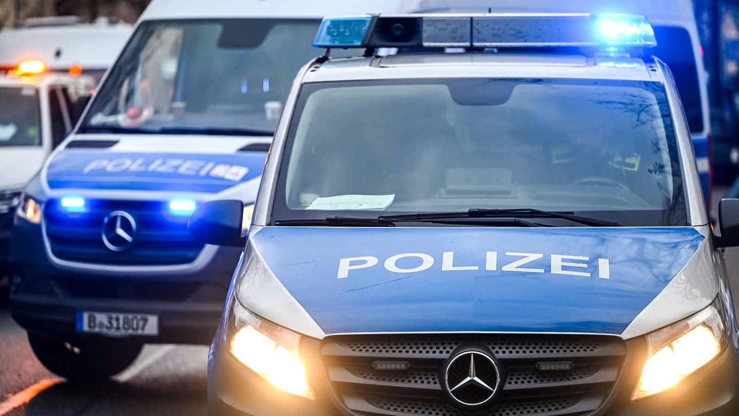 Polizeiautos mit eingeschalteten Scheinwerfern und Blaulicht in Berlin