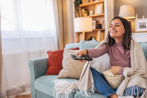 Frau schaut Fernsehen mit HD+