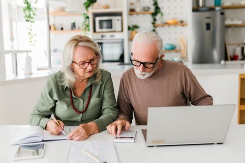 Ein Ehepaar im Rentenalter füllt Formulare aus