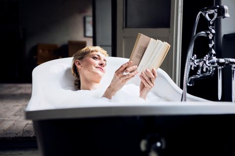 Eine Frau liegt in der Badewanne und liest Buch Neuerscheinungen 2025.