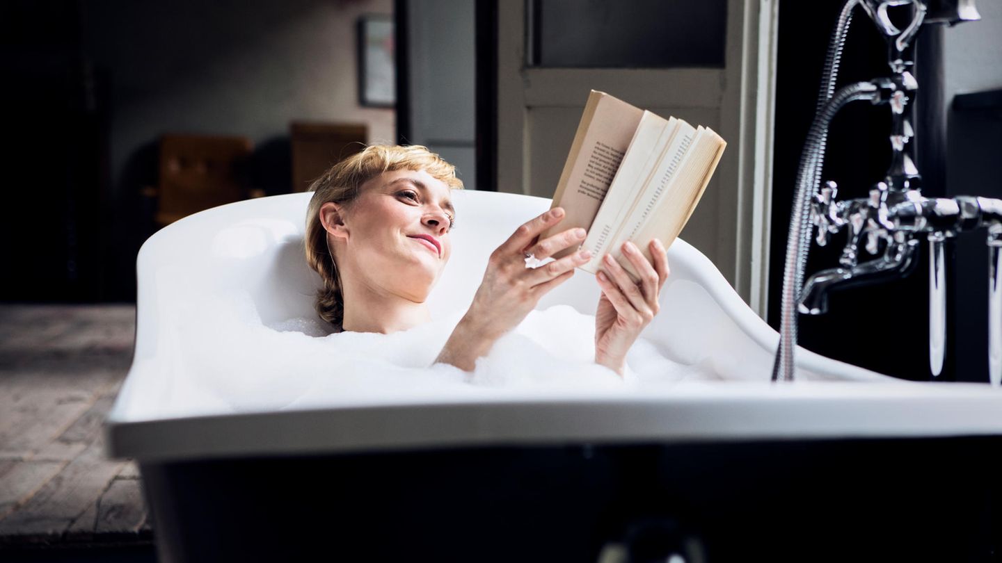 Eine Frau liegt in der Badewanne und liest Buch Neuerscheinungen 2025.