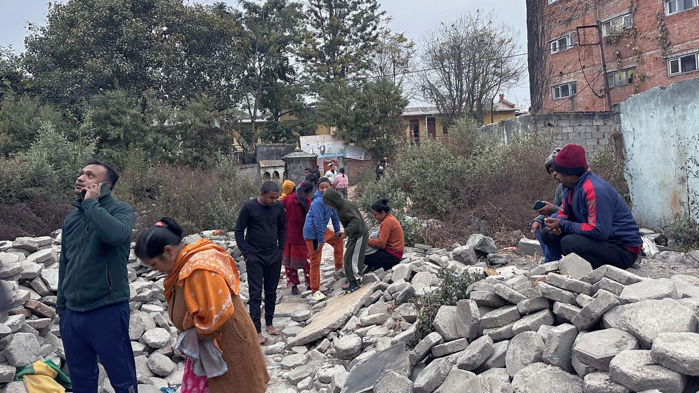 Menschen in Kathmandu versammeln sich vor ihren Häusern neben Trümmern nach einem Erdbeben