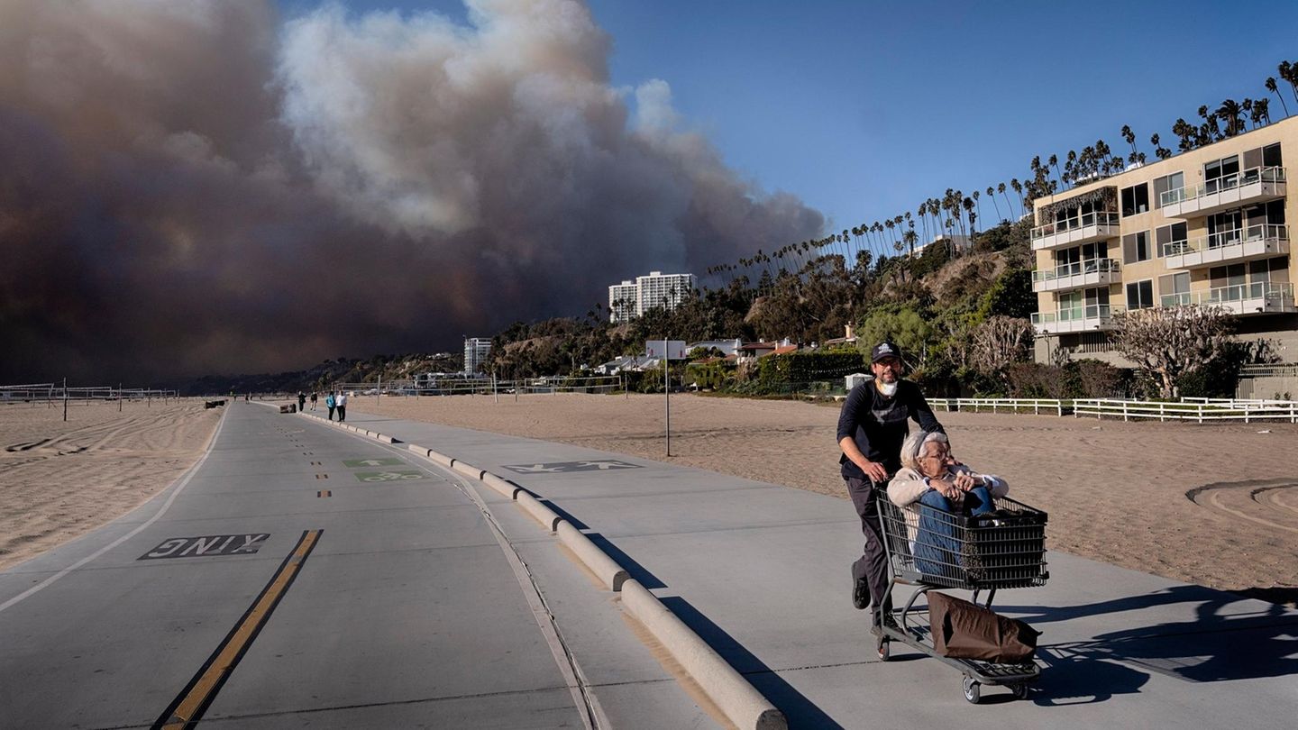 in Einwohner von Pacific Palisades schiebt seine Schwiegermutter in einem Einkaufswagen weg